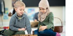 Two children playing on the floor in the classroom