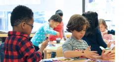 Two young boys in the classroom fingerpainting