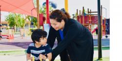 Teacher and young child on the playground