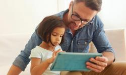 father and daughter looking at computer tablet