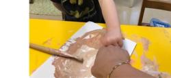 A child and teacher mixing brown paint together to match skin tones.