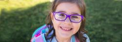 Girl with glasses standing outdoors