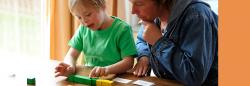 Mother and son reading cards and counting blocks