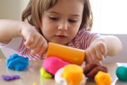 young girl rolling playdough