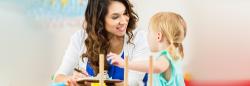 woman with clipboard talks to toddler 