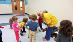 Teacher bending over and talking to students