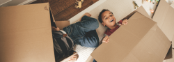 Two children playing with boxes