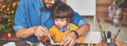 Father and son painting wooden materials