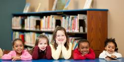 Five young children sitting at a table in the library