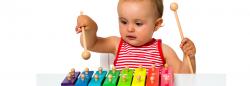 A baby playing on a toy xylophone.