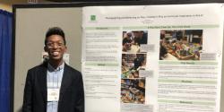 Ron Grady standing next to a poster board he presented at a conference.