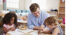 A teacher instructing young children in a classroom.