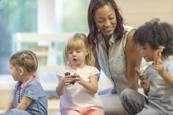 a teacher playing with children in a classroom