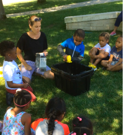 Children and an adult engage in a gardening project.