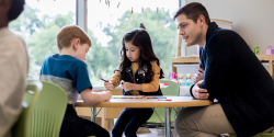 A teacher with students in a classroom.