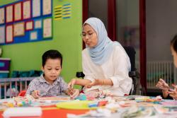 a teacher making crafts with a child