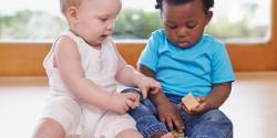 two toddlers playing with blocks together