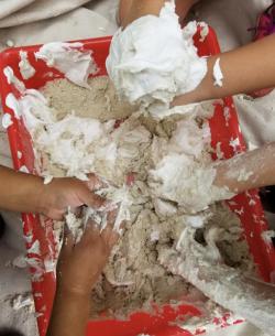 Children playing with sand and shaving cream at school