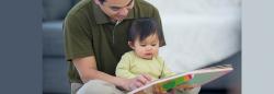 Father and daughter ready a book together on the floor