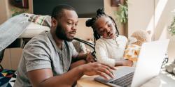 A parent browsing the computer with a child from home