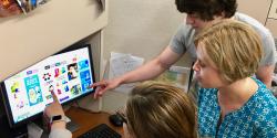 Children and an adult around a computer.