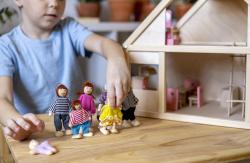 a child playing with dolls  in a doll house