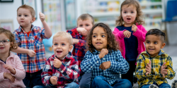 A group of children sing and move together.