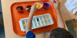 a child mixing paints in a tray