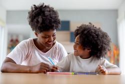 A mother teaching her daughter how to write