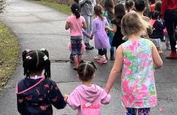 Children holding hands while walking outside