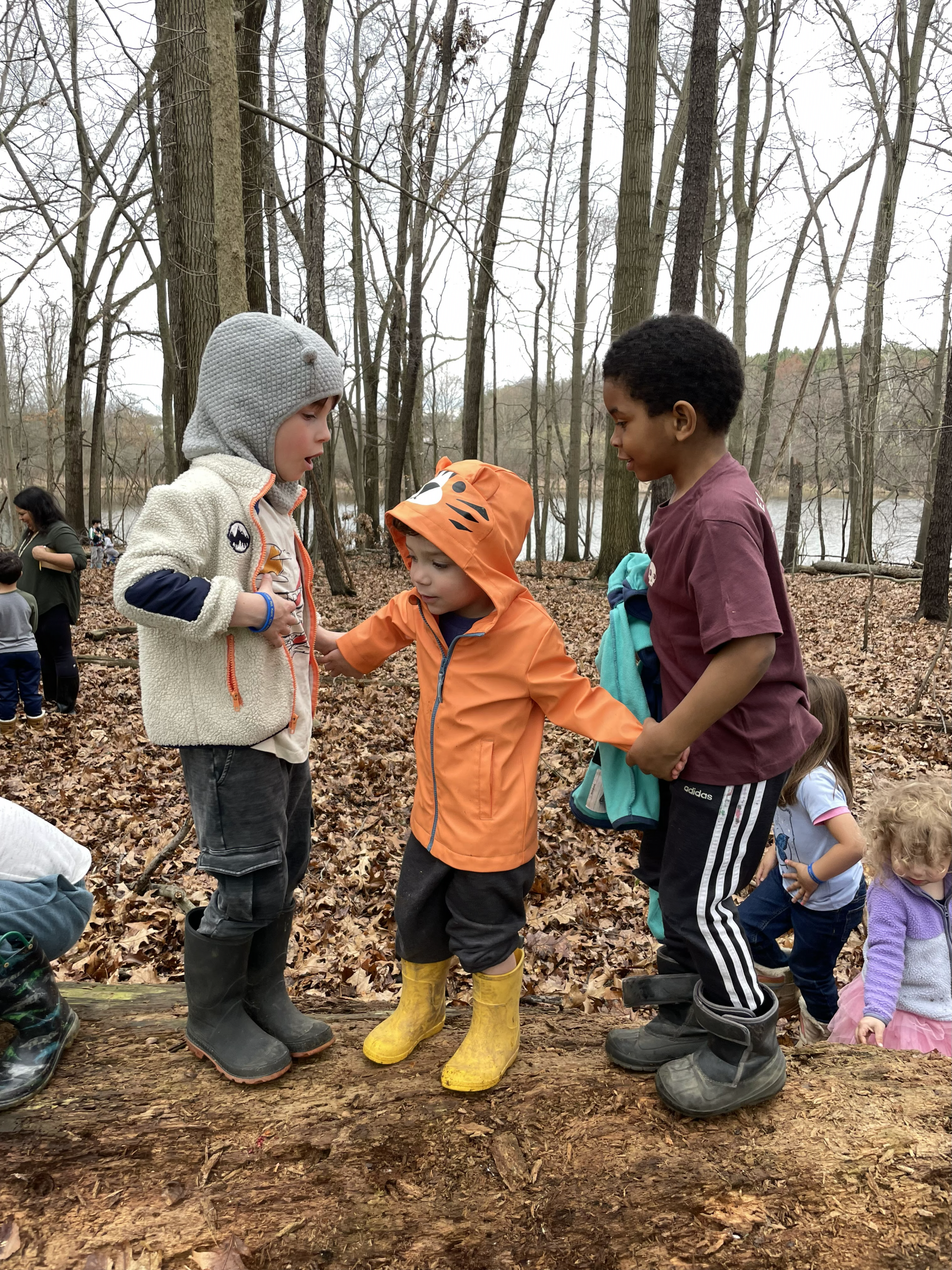 Three students playing in the woods together