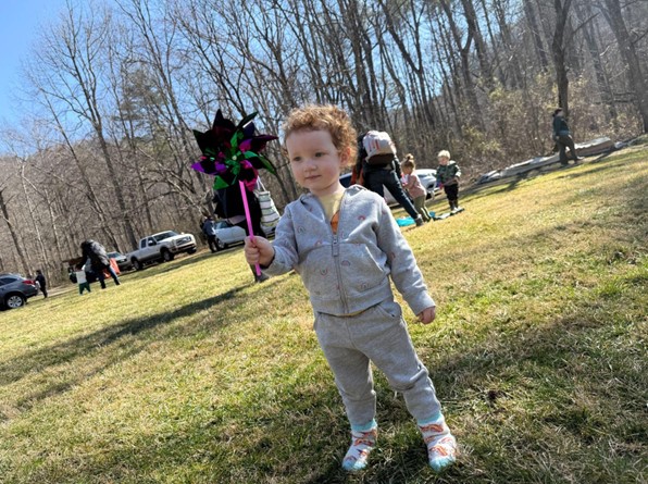 Toddler playing outside with a pinwheel