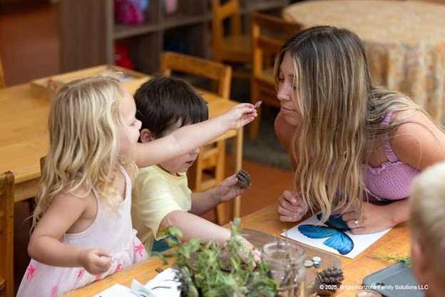 A teacher smelling a plant with students