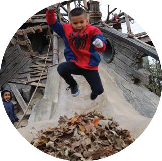 A child jumping into a pile of leaves.