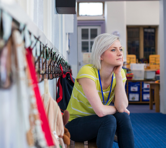 teacher sitting in classroom alone thinking